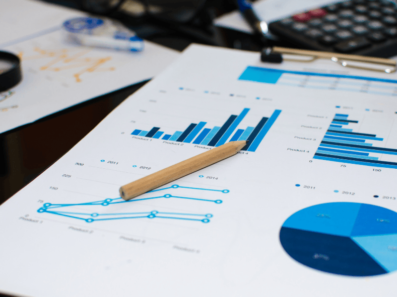 Close-up of financial reports showing bar and pie charts, symbolizing cash flow reporting and job-level profitability insights for restoration contractors