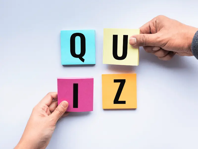 Hands arranging colorful sticky notes to spell 'QUIZ', symbolizing interactive business assessments to identify gaps in restoration claims processes