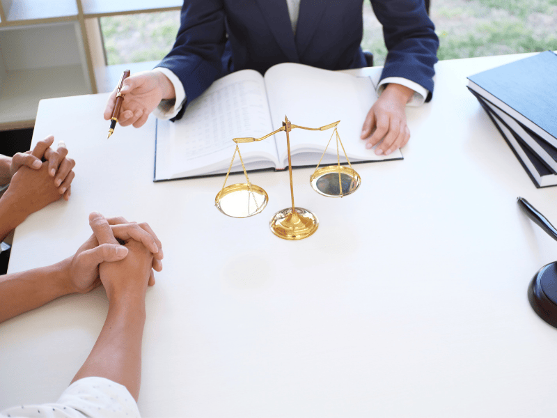 Scales of justice and legal books on a desk, symbolizing Smart Claims' corporate representation and legal defense for restoration claims