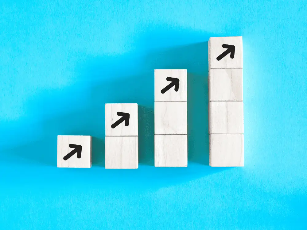 Wooden blocks with upward arrows arranged in an ascending chart, symbolizing steady growth for new restoration contractors using the Smart Start Package